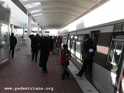 Riders exiting Metro train at new station.